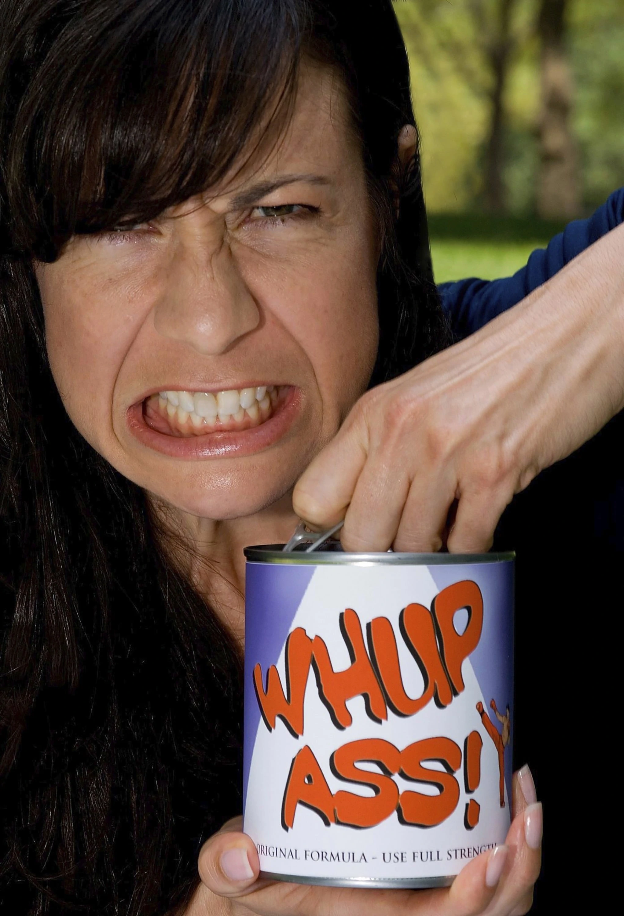 Woman grimacing as she opens a can of Whup Ass