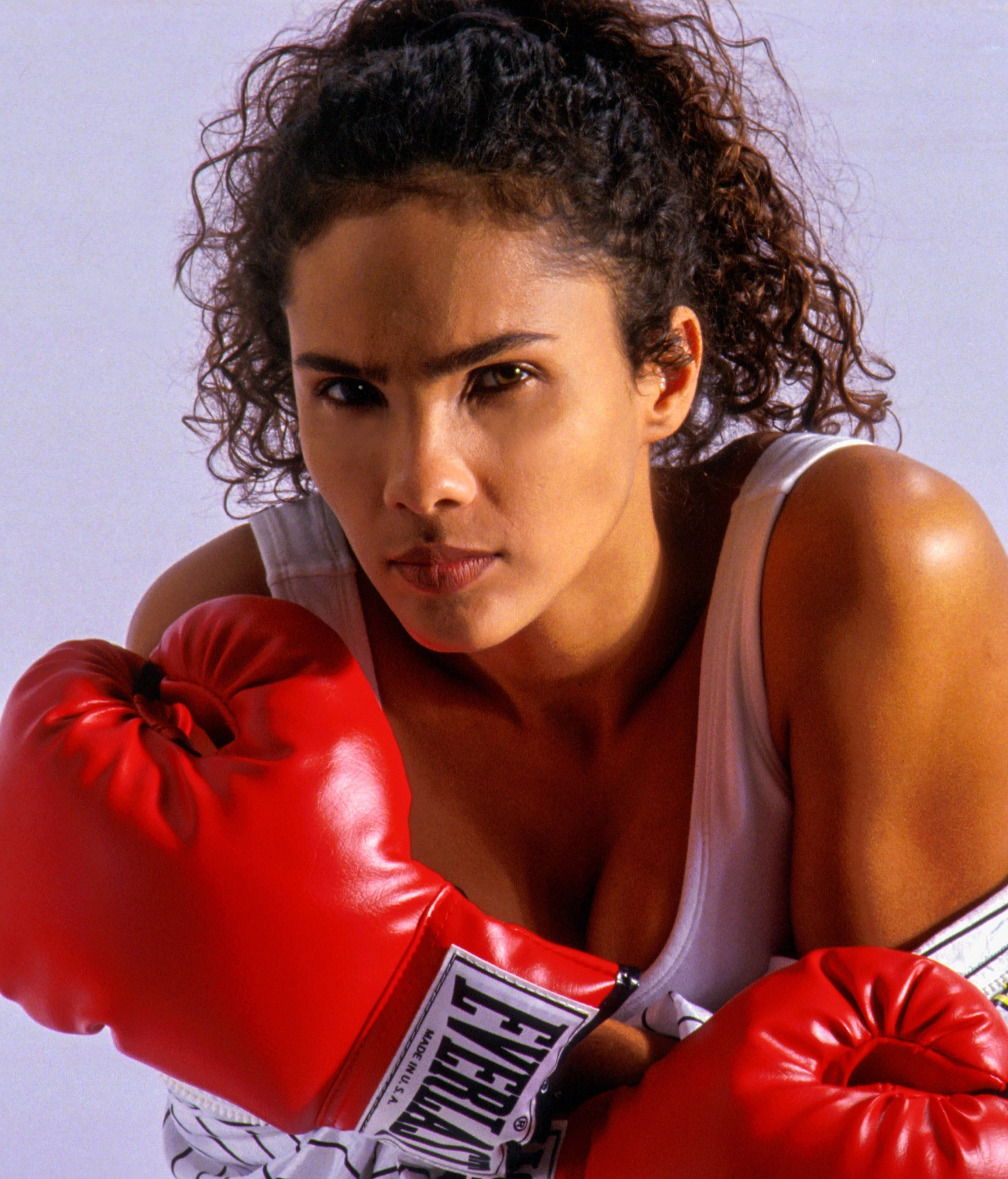 Woman wearing a tough expression and red boxing gloves