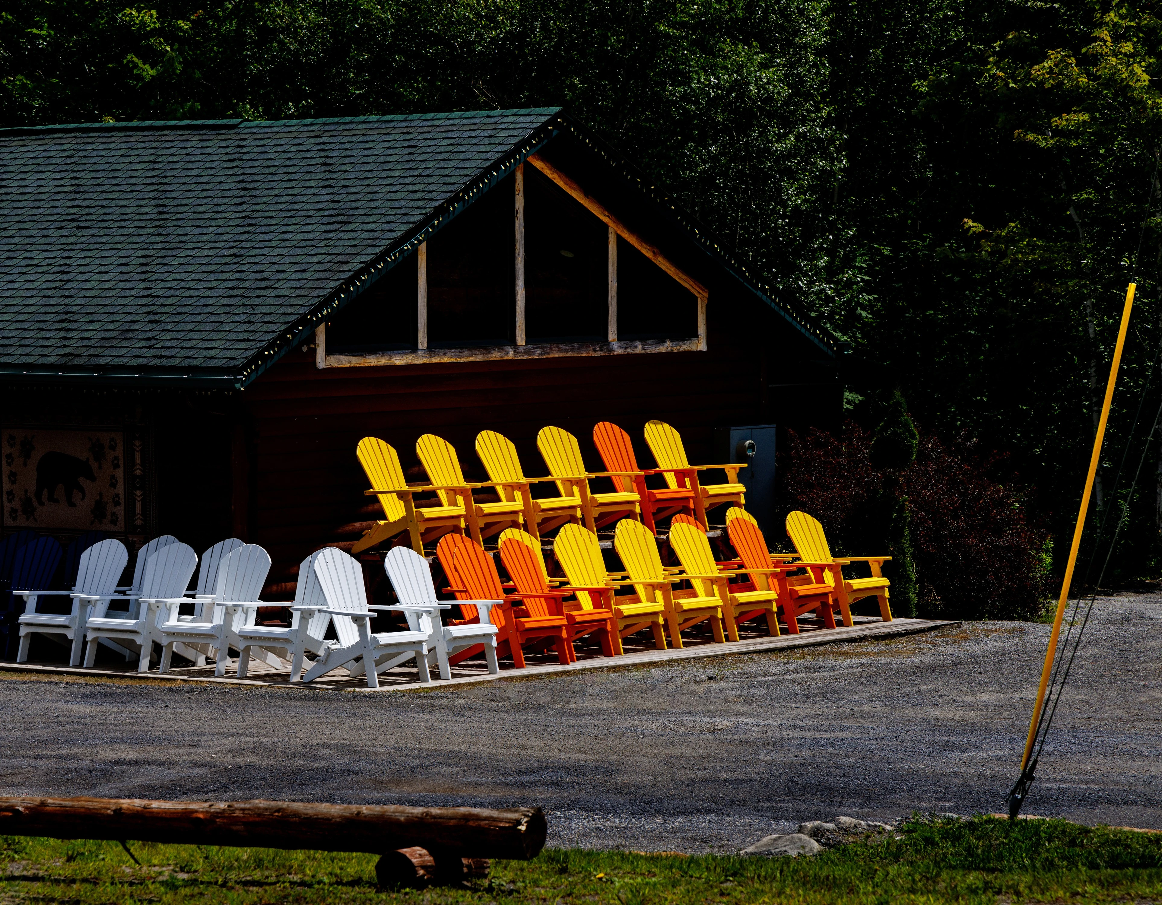 Orange yellow and white Adirondack chairs for sale on the roadside